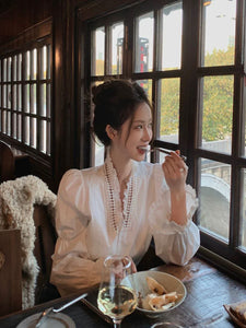 قميص نسائي أبيض بأزرار فرنسية وفتحة رقبة على شكل حرف V 